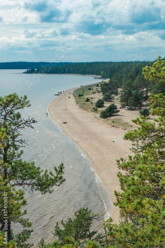 A view through pine trees of a beach coast line on Ladoga lake in Karelia shot from a a high point