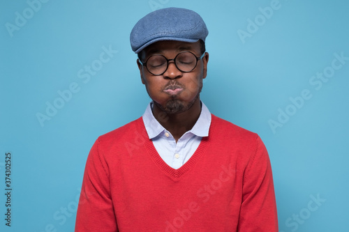 Vászonkép Young handsome african man puffing cheeks with funny face holding breath