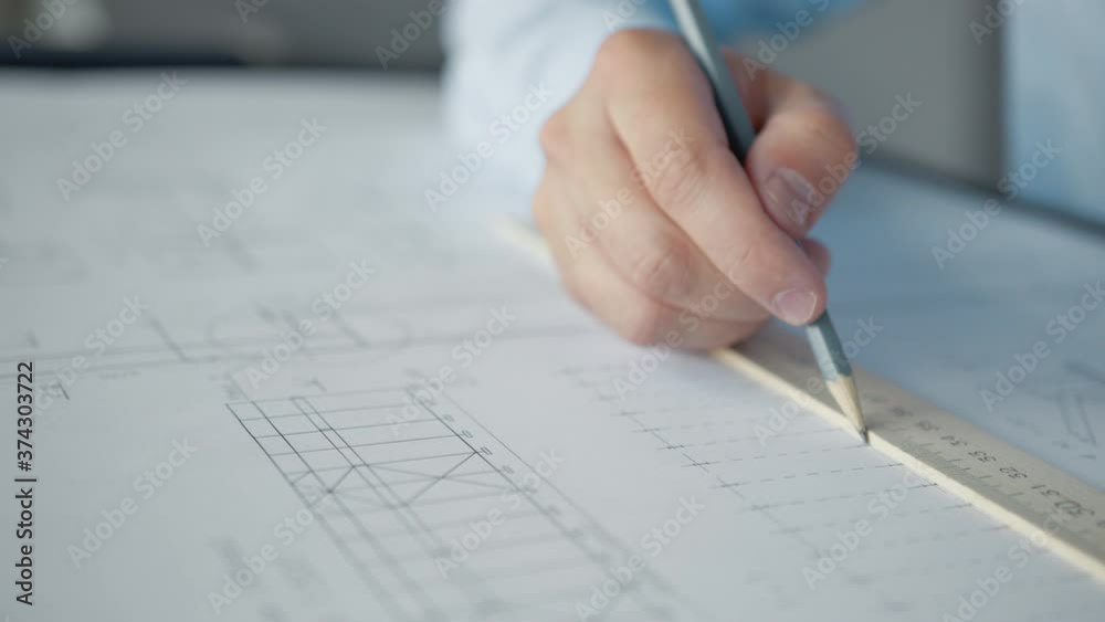 Male hands drawing construction plan in the office Male hands drawing construction plan in the office