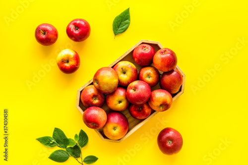 Group of red apples in wooden tray with leaves. Autumn harvest