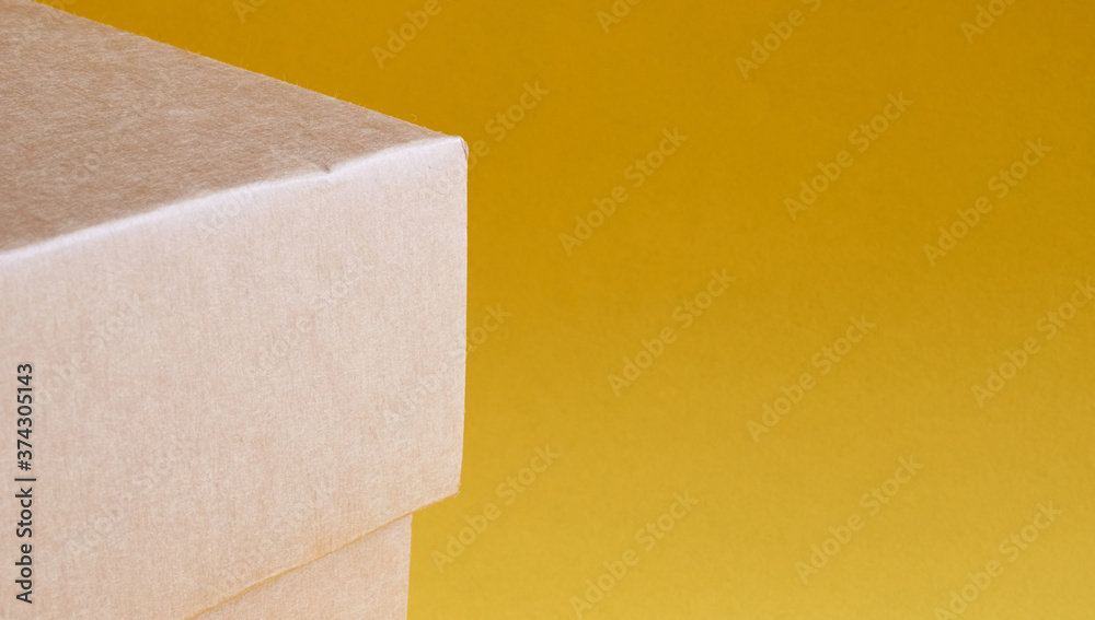 Corner of a brown cardboard box on a yellow background