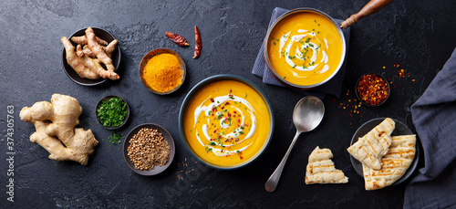 Fototapeta Naklejka Na Ścianę i Meble -  Pumpkin soup with spices in black bowl. Comfort detox food. Flat lay composition. Top view.