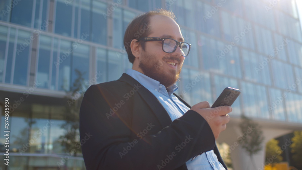 Cheerful overweight office worker surfing internet relaxing near business center. Cheerful overweight office worker surfing internet relaxing near business center.