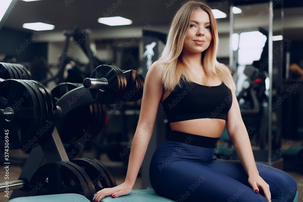 Fototapeta premium Portret młodej kobiety blondynka sprawny w czarnym sportowym biustonoszu