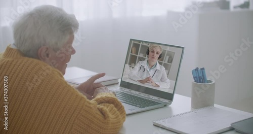 telehealth session by internet for old people and handicapped people, woman is speaking with elderly man by video call photo