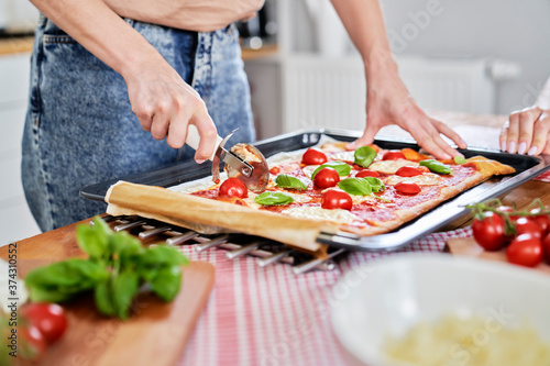 Close up of slicing homemade pizza on the table