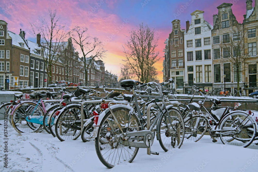 City scenic from snowy Amsterdam in the Netherlands at sunset
