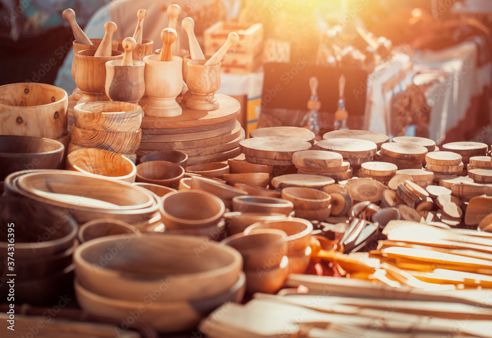 Group of wooden mortar and pestles, bowls, plates, spatulas on the countertop at antique bazaar. Shopping at sunday flea market. - obrazy, fototapety, plakaty 