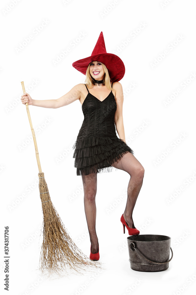 jeune et jolie femme blonde souriante déguisée en sorcière d'Halloween sexy  avec un chapeau pointu et un balai sur fond isolé blanc de studio Stock  Photo | Adobe Stock