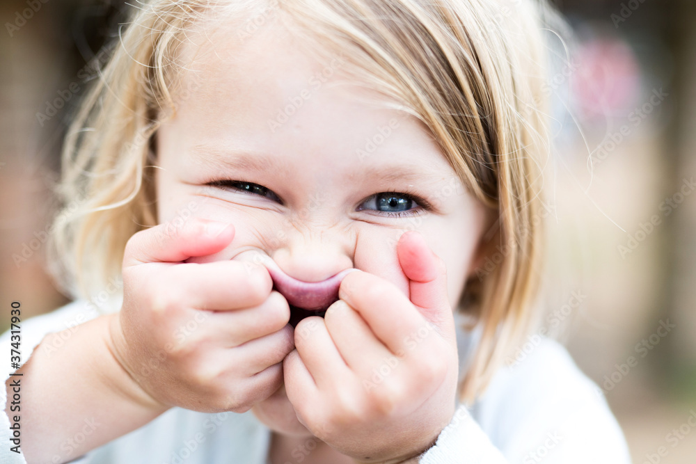 small girl pulling a face using her hands small girl pulling a face using her hands