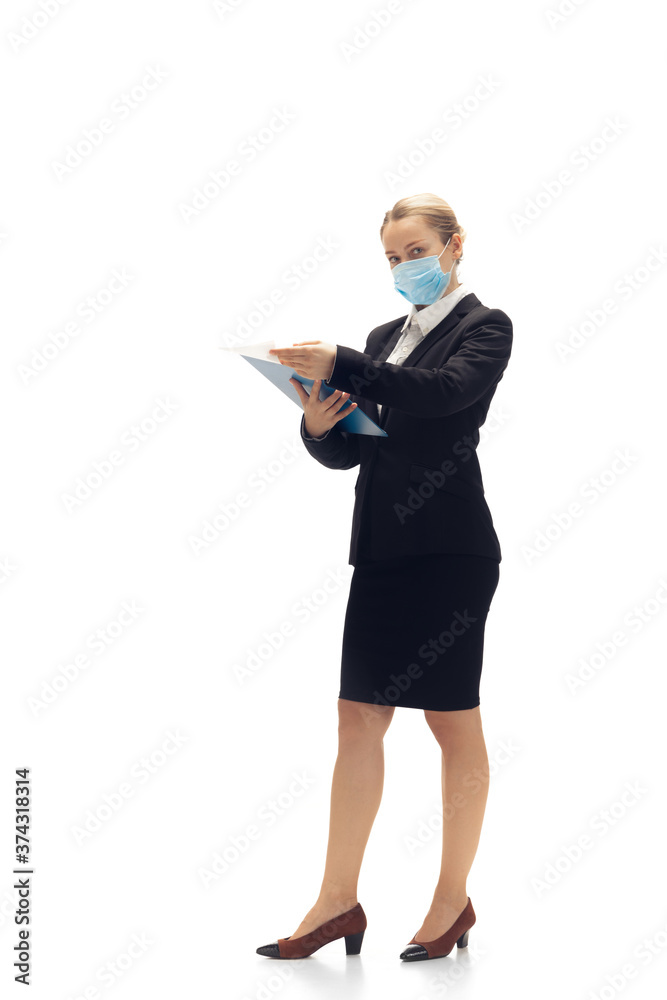 Working in face mask. Young woman, accountant, finance analyst or booker in office suit isolated on white studio background. Caucasian woman, office worker. Finance, economy, professional occupation. Working in face mask. Young woman, accountant, finance analyst or booker in office suit isolated on white studio background. Caucasian woman, office worker. Finance, economy, professional occupation.