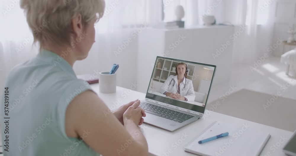 female patient is calling at hospital and talking with woman doctor by video conference on laptop, staying home female patient is calling at hospital and talking with woman doctor by video conference on laptop, staying home