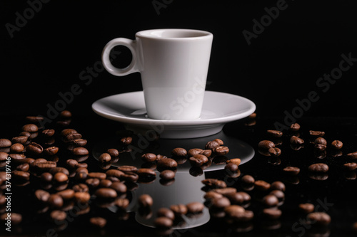 Mugful of coffee in white cup and saucer with coffee grains background photo