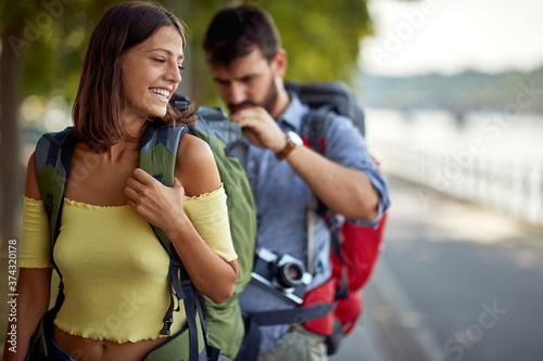 Canvas Print smiling tourists enjoying on vacation,  couple having fun walking on city street