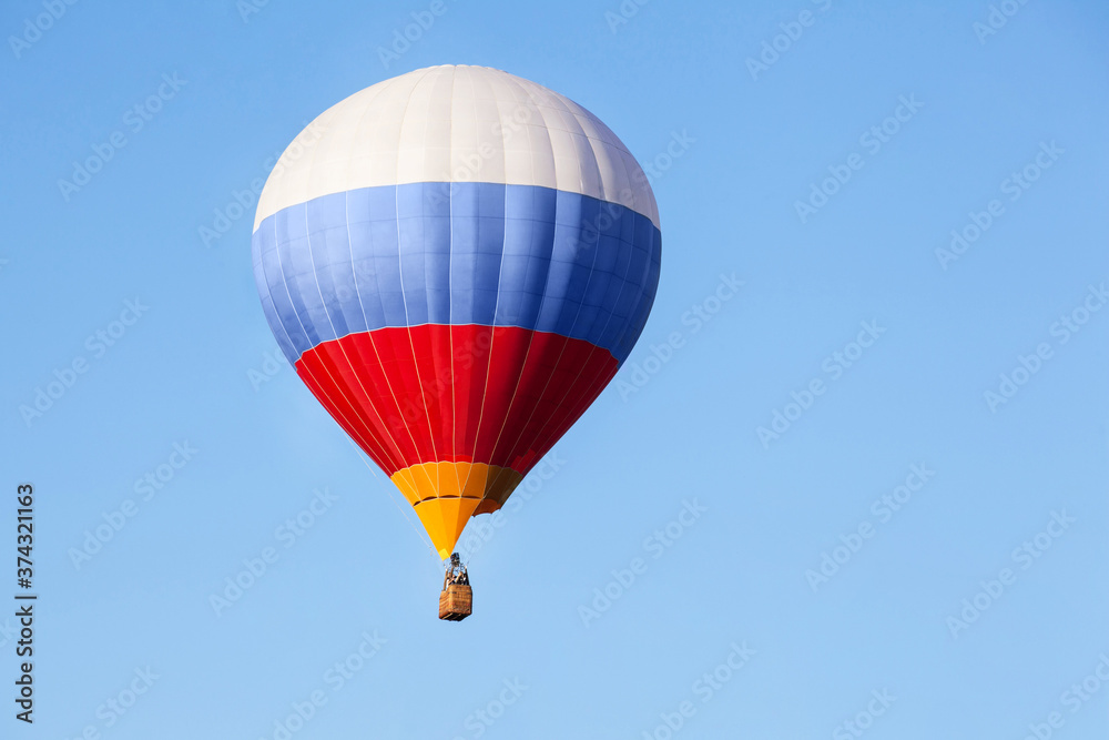 Tricolor hot air balloon flying in the blue sky. Tricolor hot air balloon flying in the blue sky.