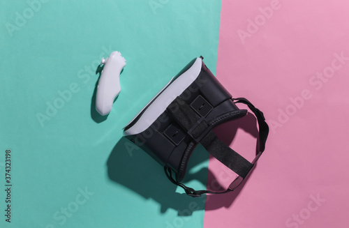 Virtual reality headset with joystick on pink blue pastel background with shadow. Top view. Flay lay. Minimalism