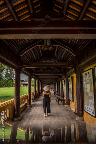 Girl walking with vietnamese hat through the imperial palace of Hue © Eleazar