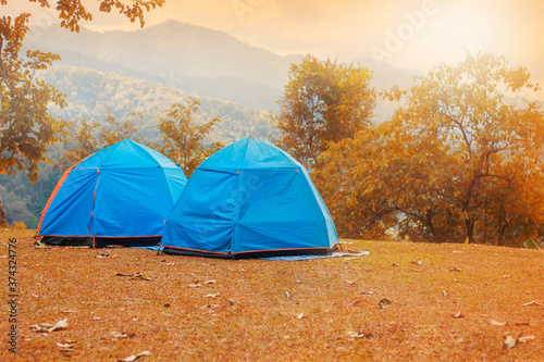 Family resting with tent in nature at sunset. Weekends