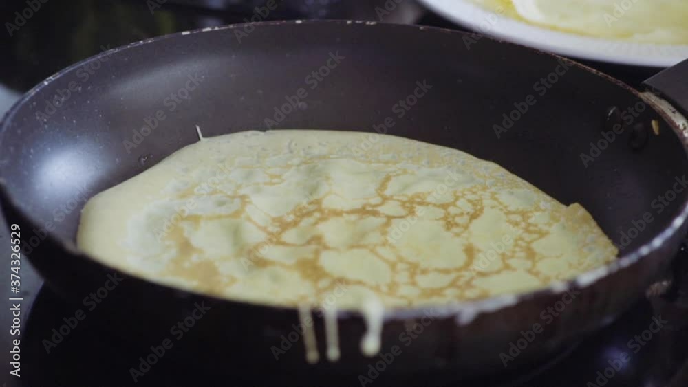 Cooking Russian pancake in old frying pan on top of electric stove. Cooking Russian pancake in old frying pan on top of electric stove.