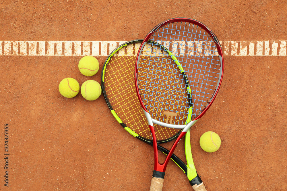 Tennis racquets with tennis balls on clay court