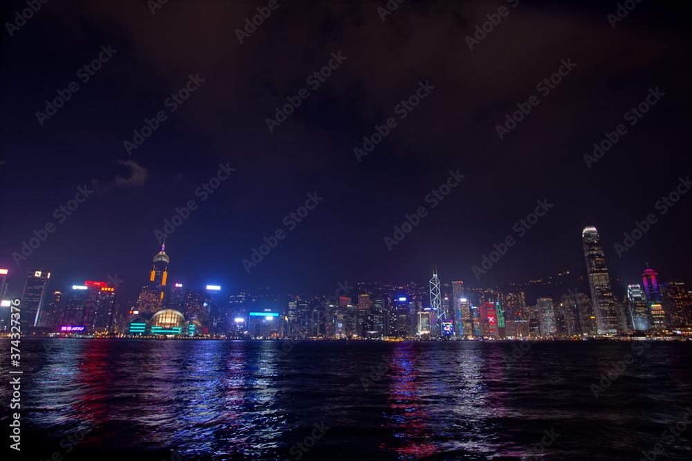 City landscape. Victoria Harbor and Hong Kong skyscrapers at night.