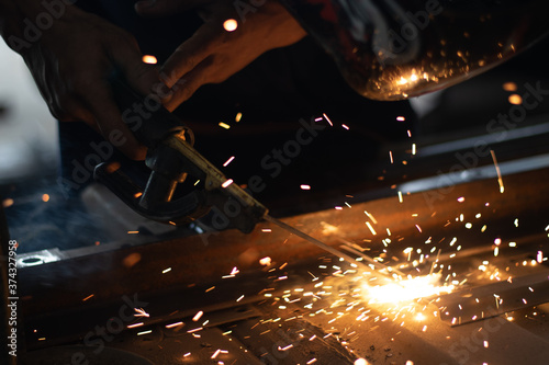 Worker,welding in a car factory with sparks, manufacturing, industry