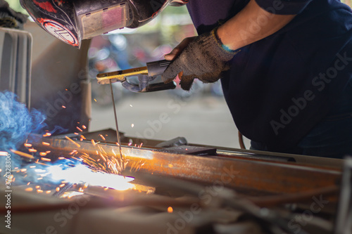 Worker welding in a car factory with sparks  manufacturing  industry