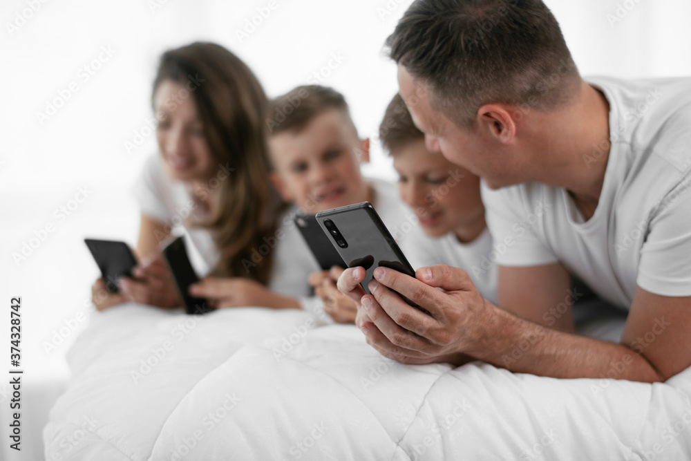 Young family playing video games on the phone. Parents and kids enjoying at home.. Young family playing video games on the phone. Parents and kids enjoying at home..