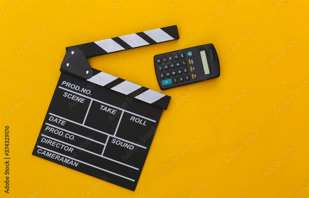 Movie clapper board and calculator on yellow background. Cinema fees. Filmmaking, Movie production. Top view