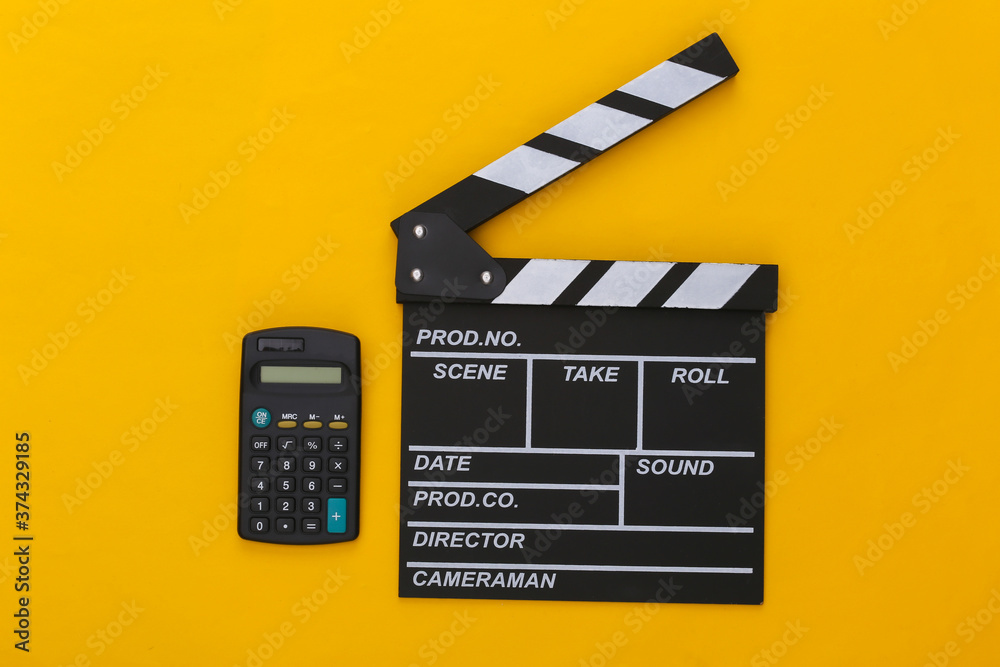 Movie clapper board and calculator on yellow background. Cinema fees. Filmmaking, Movie production. Top view