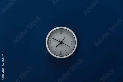 White clock on classic blue background. Color 2020. Top view.