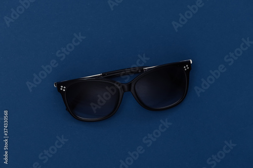 Sunglasses on classic blue background. Color 2020. Top view.