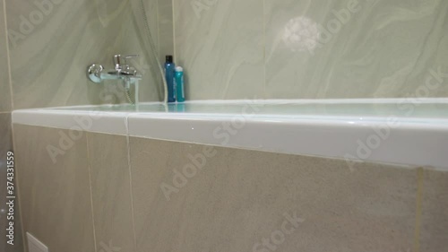 Flood in the bathroom, water is poured from the bathtub
