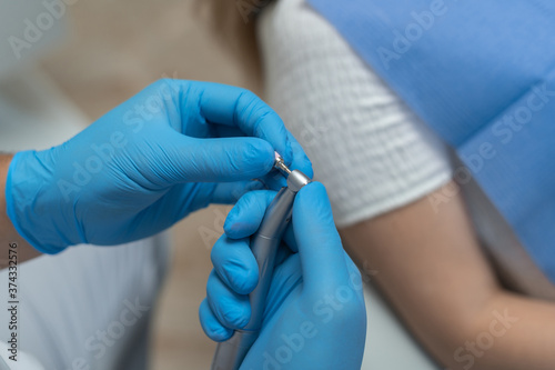 dentist s hand in blue gloves holding a tool