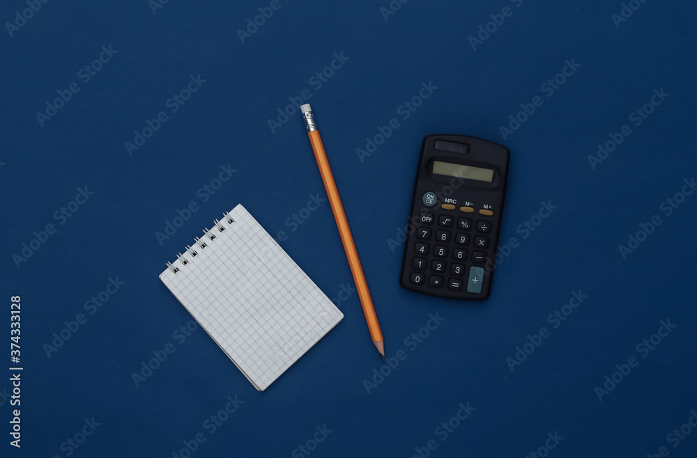 Notepad with pencil and smartphone on a classic blue background. Modern gadgets. Color 2020. Top view. Notepad with pencil and smartphone on a classic blue background. Modern gadgets. Color 2020. Top view.