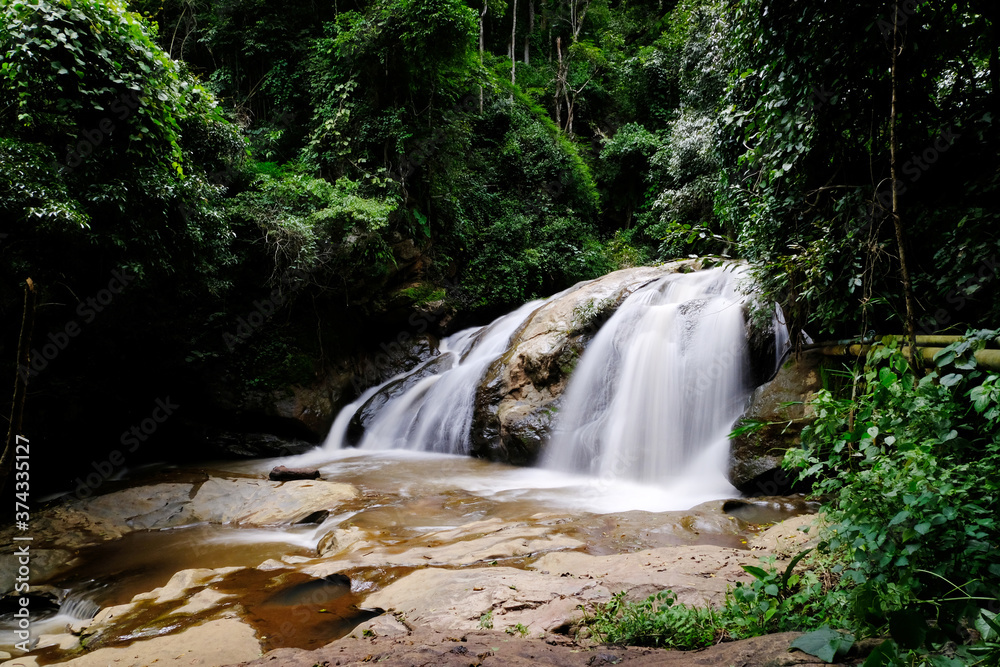 Obraz premium Beautiful waterfall in the forest wallpaper background