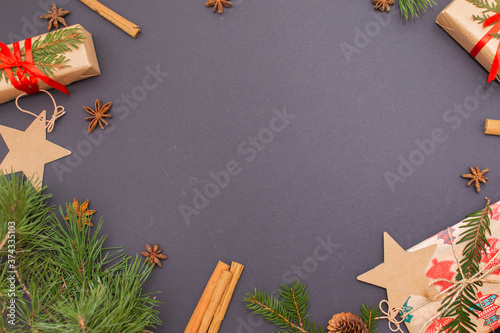 Gifts, cinnamon, bumps, Christmas tree twigs on a black background. Flat lay