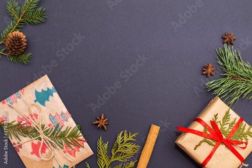 Gifts, cinnamon, Christmas tree twigs on a black background. Flat lay