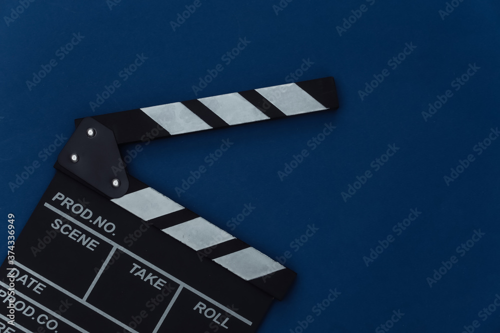 Obraz premium Movie clapper board on classic blue background. Filmmaking, Movie production, Entertainment industry. Color 2020. Top view