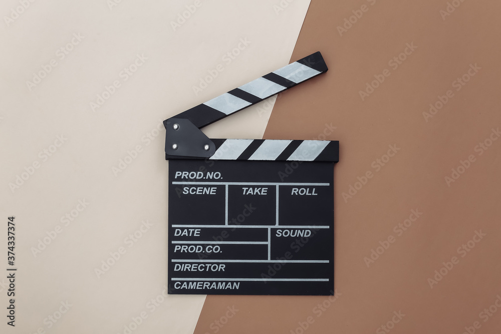 Movie clapper board on beige brown background. Filmmaking, Movie production, Entertainment industry. Top view