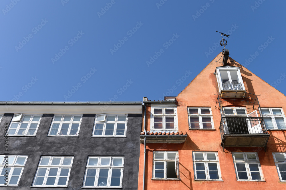 Fototapeta premium Colorful houses in black and orange of the Nyhaven in Copenhagen Denmark on a sunny day with a bright blue sky.