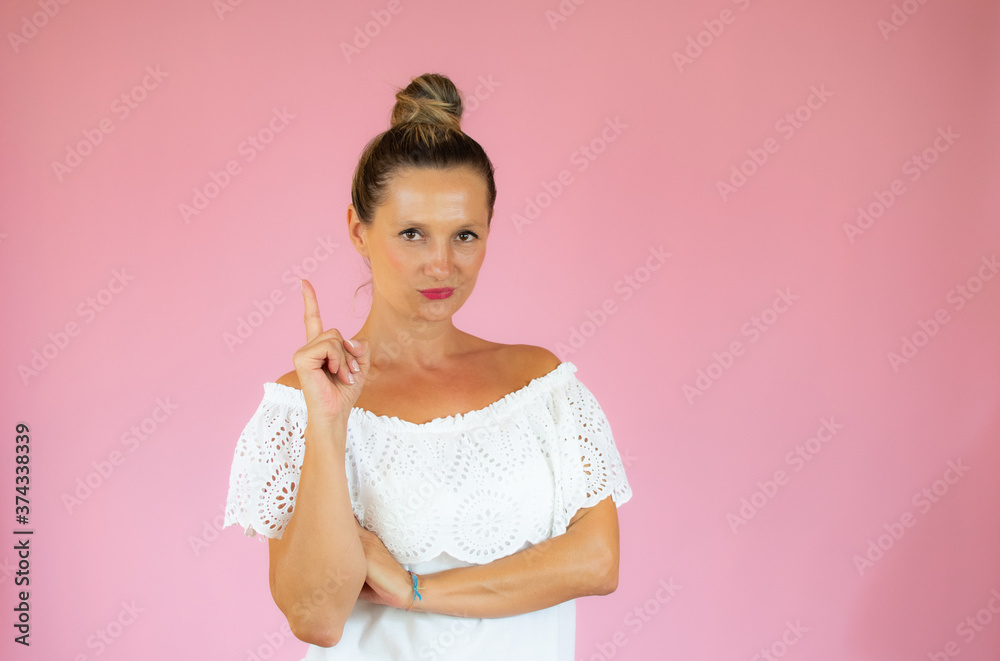 Beautiful woman pointing up on pink background Beautiful woman pointing up on pink background