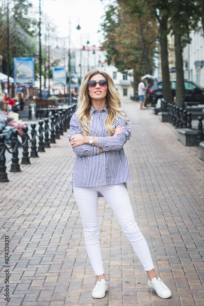 Summer street fashion, stylish hipster girl in sunglasses, city street