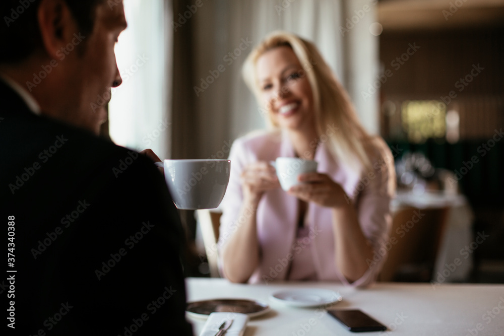 Beautiful businesswoman dressed in the suit drinking coffee. Businesswoman enjoying in the restaurant..