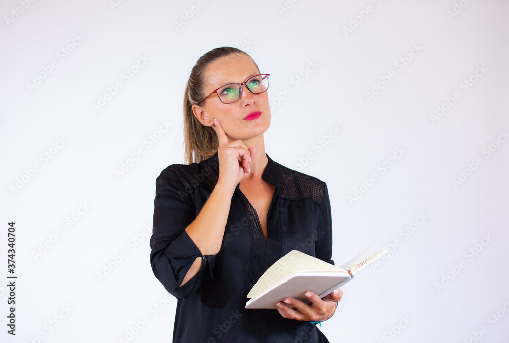 Pretty businesswoman with a notebook with doubtful gesture