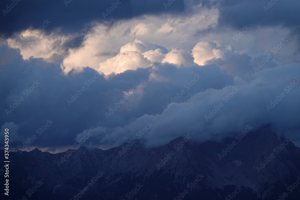 sunrise with dark clouds and sunlight over the mountains