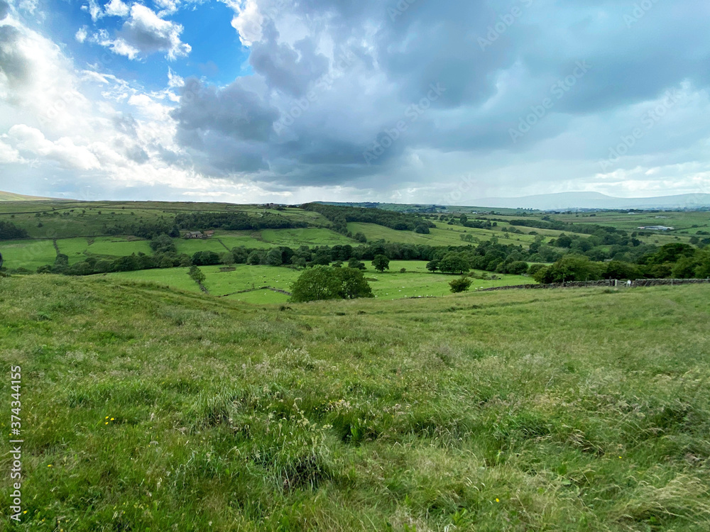 Landscape view, near Wycoller, with wild plants, fields, and meadows, and heavy rain clouds, near, Wycoller, Colne, UK Landscape view, near Wycoller, with wild plants, fields, and meadows, and heavy rain clouds, near, Wycoller, Colne, UK