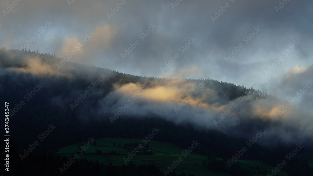 sunrise with dark clouds and sunlight over the mountains