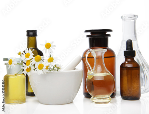 Composition of medicine bottles, herb and flower isolated on white.