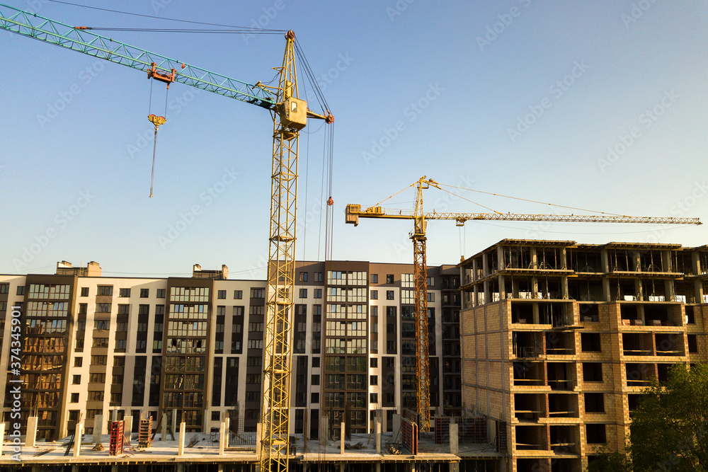 High multi storey residential apartment buildings under construction. Concrete and brick framing of high rise housing. Real estate development in urban area.